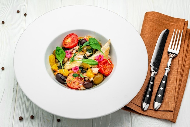 Insalata con filetto di pesce, olive aranciate, spinaci e gamberi