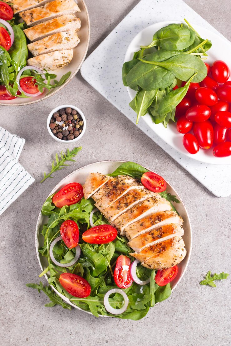 Insalata con filetto di pollo alla griglia, verdure fresche, spinaci, rucola, cipolla rossa e pomodoro.
