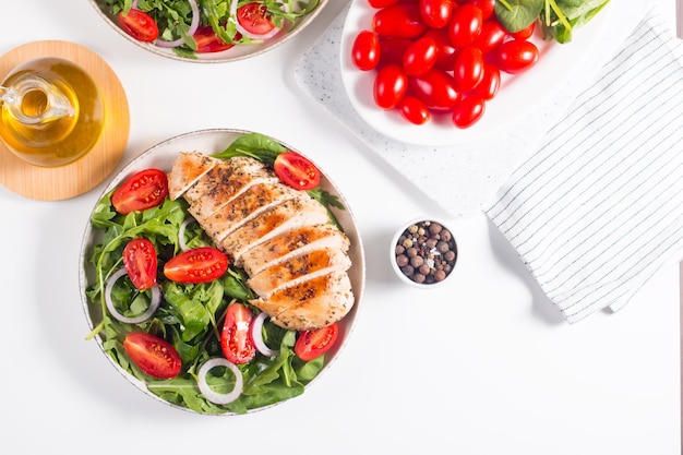 Insalata con filetto di pollo alla griglia, verdure fresche, spinaci, rucola, cipolla rossa e pomodoro.