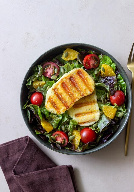 Insalata con formaggio halloumi grigliato pomodori arancia e semi di zucca Alimentazione sana Cibo vegetariano Dieta Keto