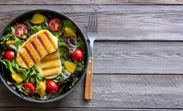 Insalata con formaggio halloumi grigliato pomodori arancia e semi di zucca Alimentazione sana Cibo vegetariano Dieta Keto