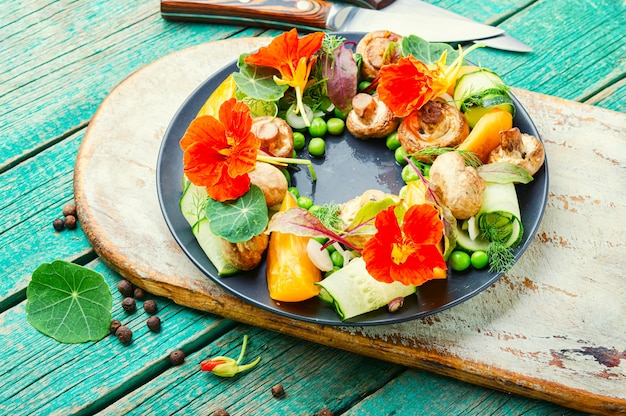 Insalata con funghi in umido, cetriolo, pomodoro e nasturzio. Insalata dietetica primaverile