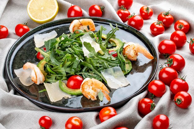 Insalata con gamberetti, pomodorini, avocado e rucola su fondo tessile