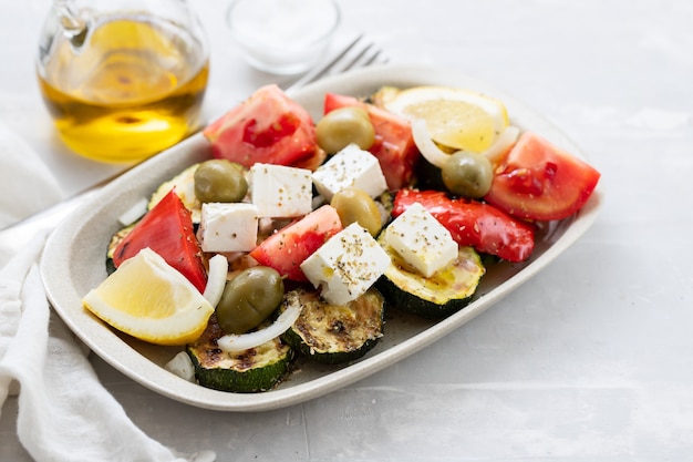 Insalata con insalata fresca e grigliata su piatto bianco su ceramica grigia