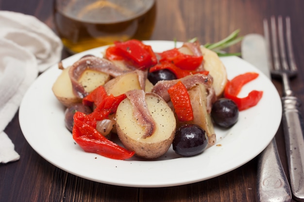 Insalata con le acciughe sul piatto bianco