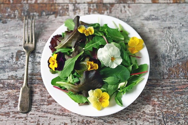 Insalata con le viole su una zolla bianca