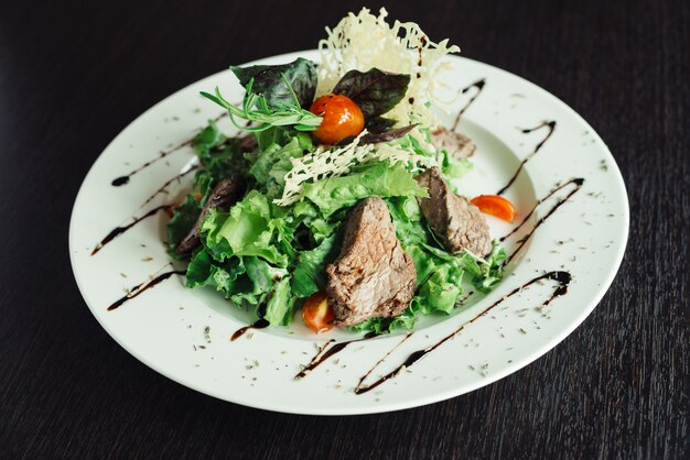 Insalata con manzo e verdi su un piatto bianco