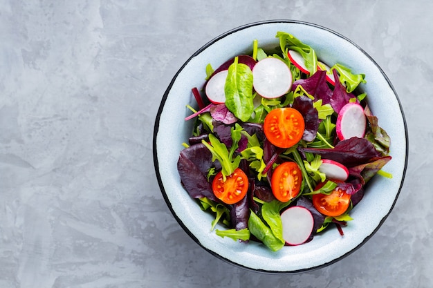 Insalata con mix di verdure su sfondo grigio