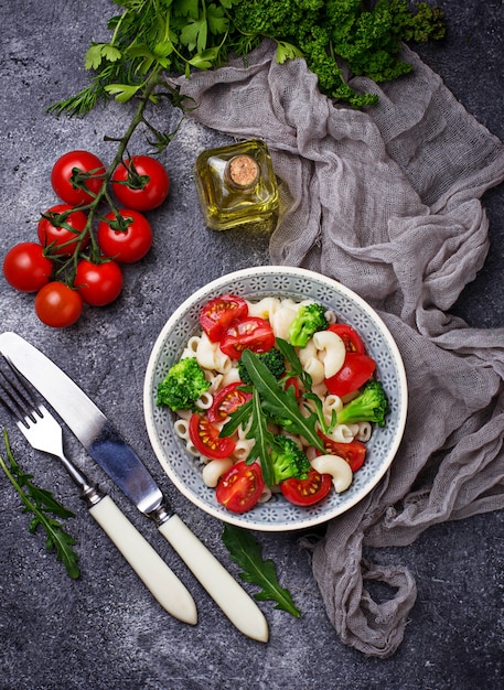 Insalata con pasta, pomodorini, broccoli e rucola. Cibo vegano