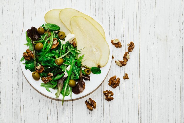 Insalata con pere erbe aromatiche arugula prosciutto formaggio olive verdi e noci