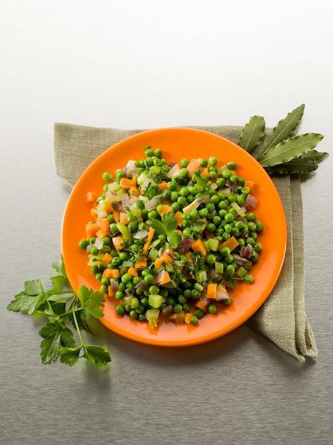 Insalata con piselli, carote e cipolle saltate in padella cibo sano