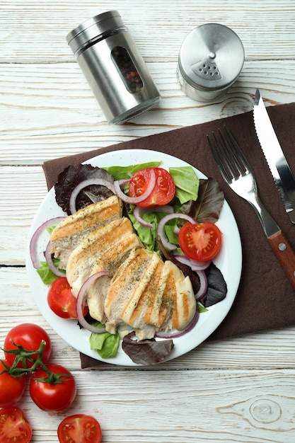 Insalata con pollo alla griglia sulla tavola di legno bianca