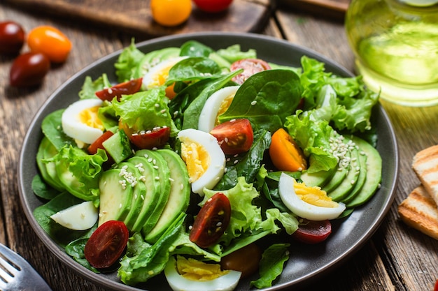 Insalata con pomodori avocado spinaci in un piatto Insalata vegetariana