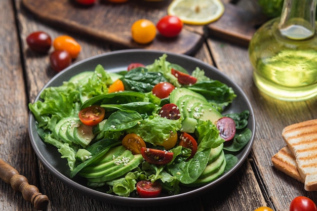 Insalata con pomodori avocado spinaci in un piatto Insalata vegetariana