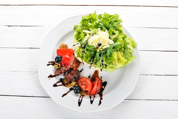 Insalata con pomodori rucola e pomodori affumicati su sfondo di legno Vista dall'alto Copia spazio