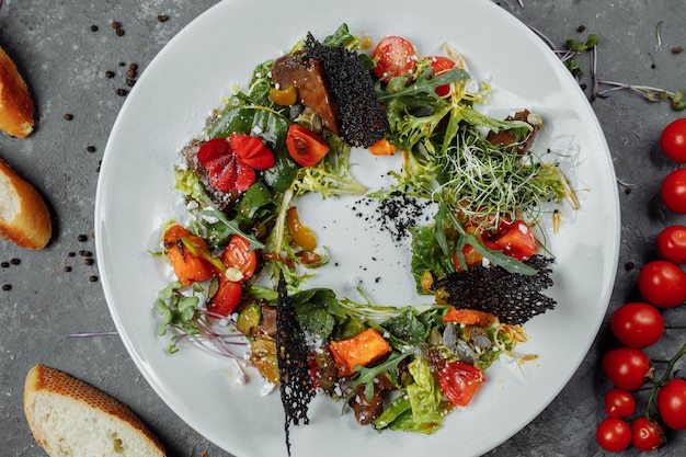 Insalata con pomodori zucca e fegato fritto. Insalata di Halloween.