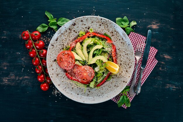 Insalata con pomodoro avocado e verdure fresche su sfondo di legno Vista dall'alto Spazio di copia