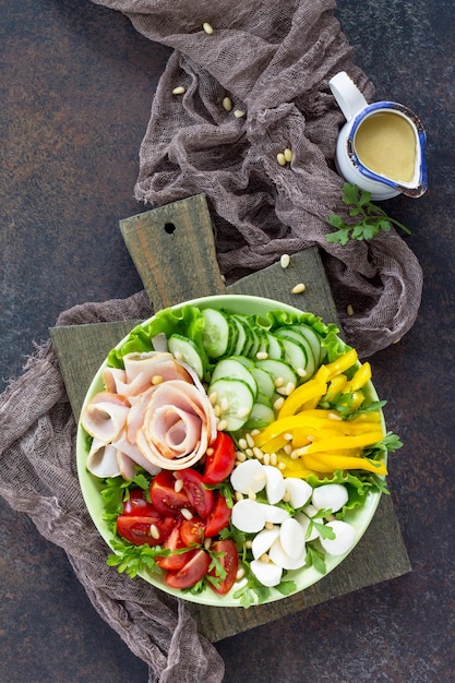 Insalata con prosciutto, verdure fresche, pinoli e mozzarella Vista dall'alto Copia spazio