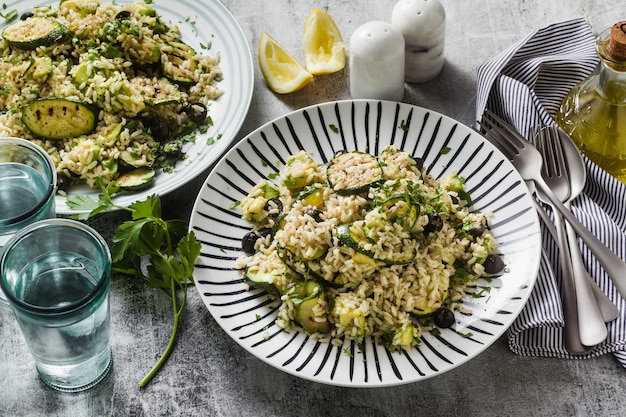 Insalata con riso con zucchine, avocado, olive e capperi