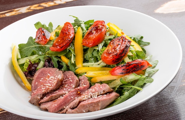 Insalata con roast beef e pomodori secchi su fondo scuro