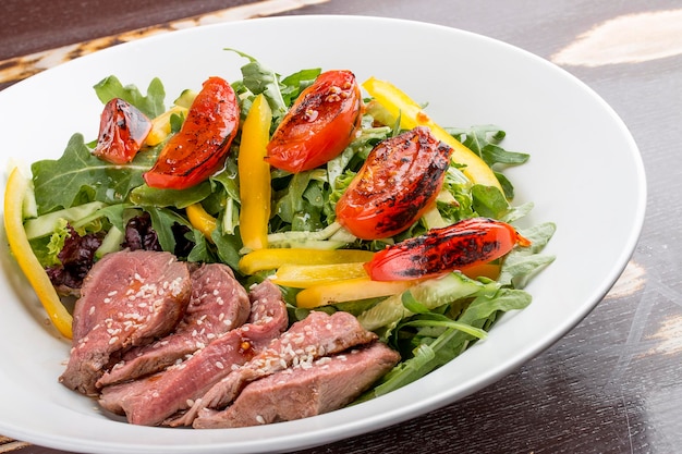 Insalata con roast beef e pomodori secchi su fondo scuro