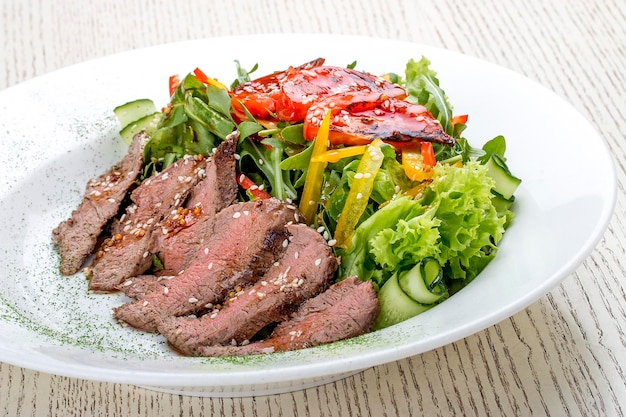 Insalata con roast beef e pomodori secchi su sfondo bianco