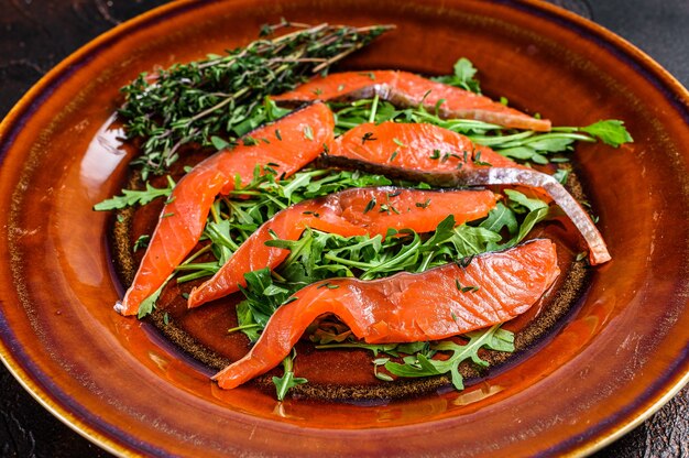 Insalata con rucola e fette di filetto di salmone affumicato.