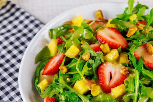 Insalata con rucola, fragole, mango e pistacchi