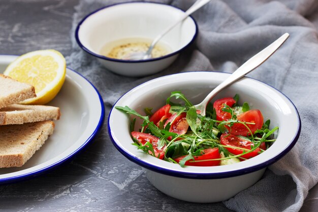 Insalata con rucola, pomodori, cetrioli e salsa al limone.