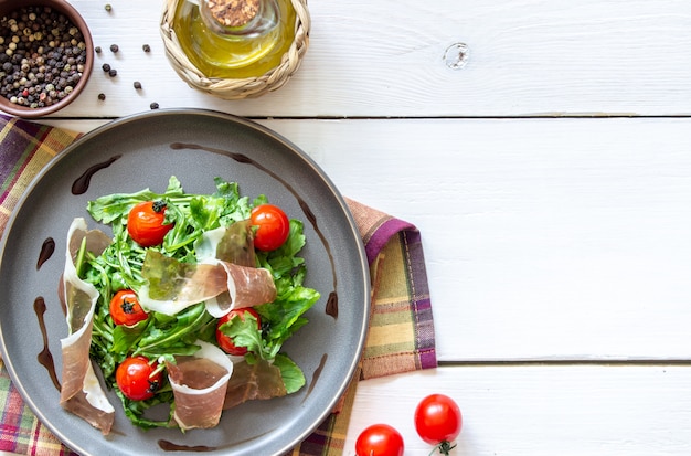 Insalata con rucola, pomodori e prosciutto.