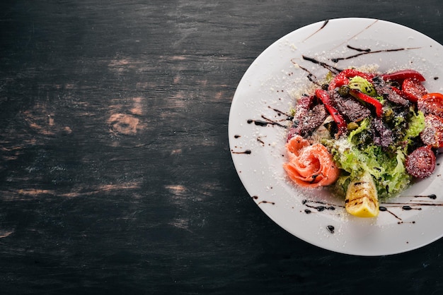 Insalata con salmone e pomodori Cucina italiana su sfondo di legno Vista dall'alto Copia spazio