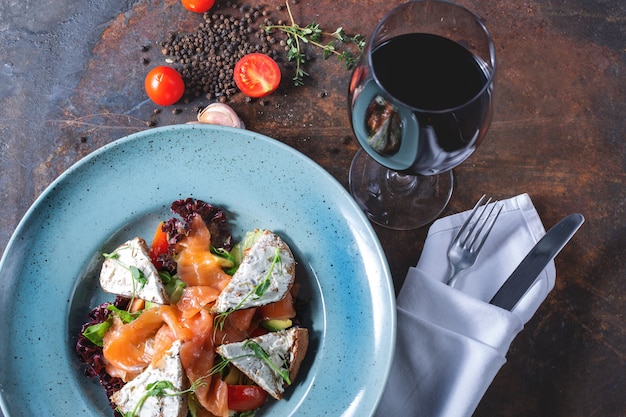 Insalata con salmone leggermente salato e un bicchiere di vino