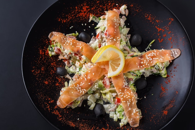 Insalata con salmone, verdure e limone sulla banda nera