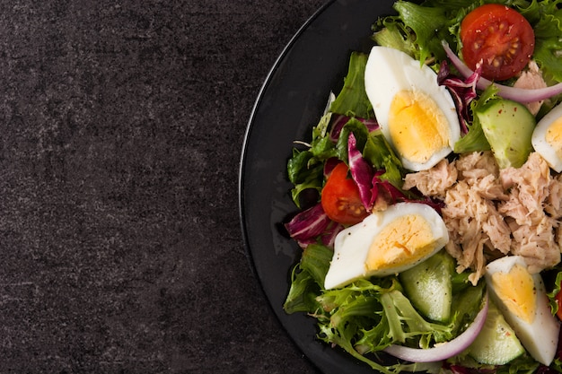 Insalata con tonno, uovo e verdure sul nero