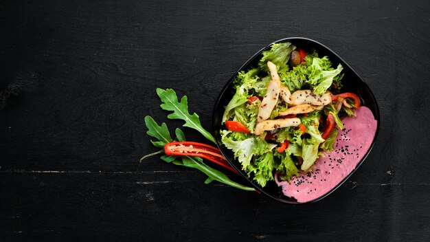 Insalata con verdure e pollo Su uno sfondo di legno Vista dall'alto Spazio libero per il testo