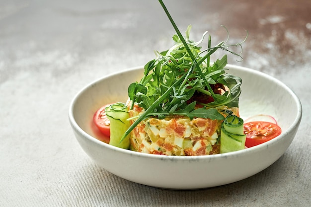 Insalata con verdure e salmone in un piatto su uno sfondo testurizzato. Primo piano, fuoco selettivo