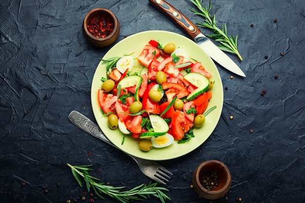 Insalata con verdure, olive, uova e rosmarino.Lay flat