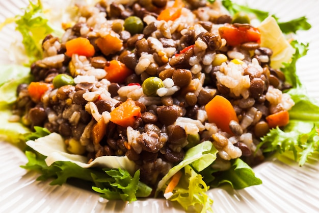 Insalata con verdure, riso e lenticchie su un piatto