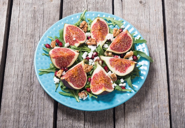 Insalata d'autunno di fichi con formaggio, ruggola, noci e melograno Cibo sano