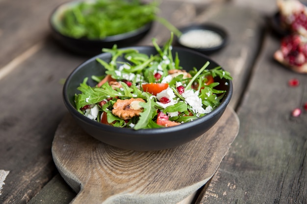 Insalata deliziosa con rucola e formaggio di capra sul piatto bianco, vista superiore, spazio della copia