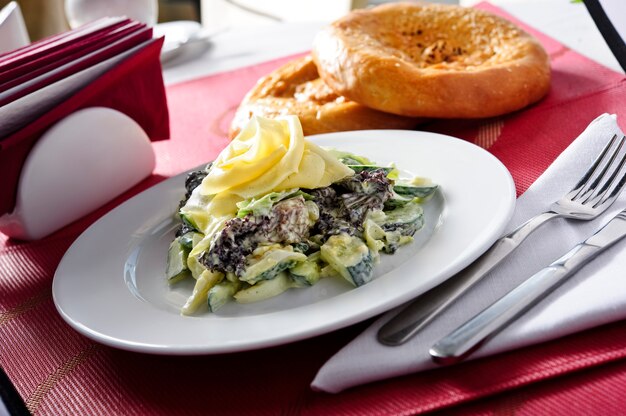 Insalata della carne della foresta con la salsa di panna acida su una pentola su una tavola di legno, orizzontale.