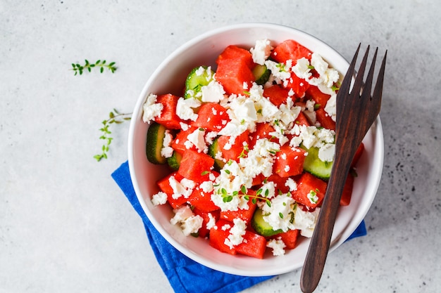 Insalata di anguria, cetriolo e feta in ciotola bianca.