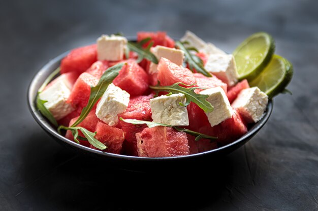 Insalata di anguria con formaggio feta, rucola e lime in una ciotola