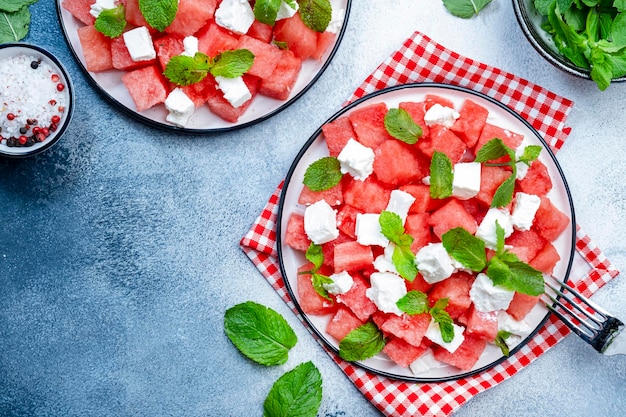 Insalata di anguria succosa estiva rinfrescante con formaggio feta e sfondo grigio menta fresca vista dall'alto spazio copia