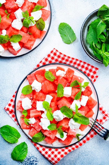 Insalata di anguria succosa estiva rinfrescante con formaggio feta e sfondo grigio menta fresca vista dall'alto spazio copia