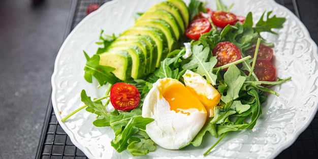 insalata di avocado uovo in camicia rucola pomodoro insalata verde foglie pasto sano spuntino sul tavolo