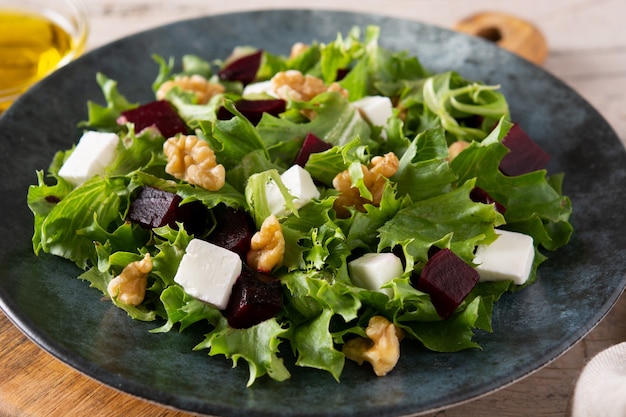 Insalata di barbabietole con feta, lattuga e noci su tavola in legno rustico