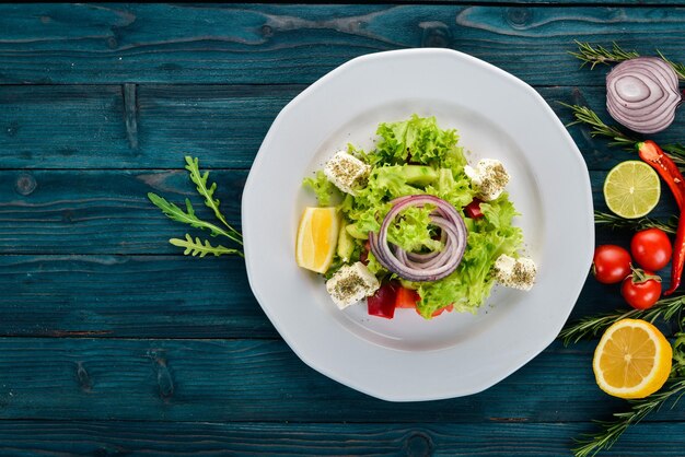 Insalata di barbabietole fresche pomodori e lattuga Cibo sano su un tavolo di legno blu Vista dall'alto Spazio libero per il testo