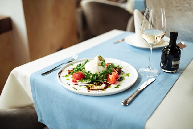 Insalata di buratta spagnola con verdure e verdure sul tavolo del ristorante servito