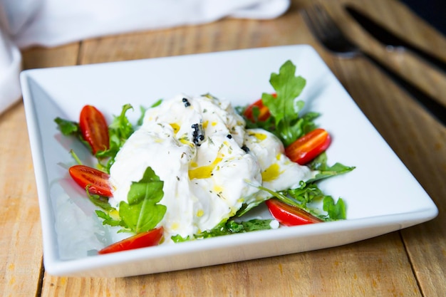 Insalata di burrata La burrata è un formaggio di latte vaccino fresco a pasta filata e di forma tondeggiante